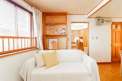 a living room with a white couch and a window at mukai Apt - 5 min walk to Itabashi subway 1stop 3min to Ikebukuro in Tokyo