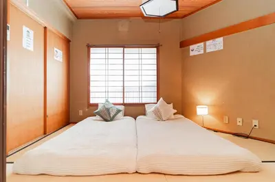 two beds in a room with a large window at mukai Apt - 5 min walk to Itabashi subway 1stop 3min to Ikebukuro in Tokyo
