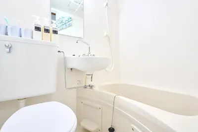 a white bathroom with a toilet and a sink at 21sqm cozy studio 5min to JR sta Great Access to Shinjuku Shibuya in Tokyo