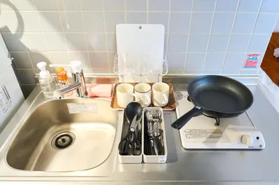 a kitchen sink with a frying pan and utensils at 21sqm cozy studio 5min to JR sta Great Access to Shinjuku Shibuya in Tokyo