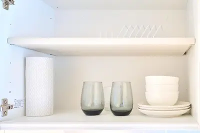 a shelf with two glasses and plates on it at 21sqm cozy studio 5min to JR sta Great Access to Shinjuku Shibuya in Tokyo