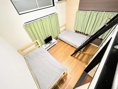 a small room with two beds and a window at HillTop Sendagi 102 in Tokyo