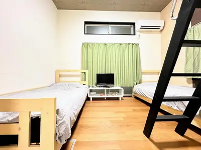 a bedroom with two bunk beds and a television at HillTop Sendagi 102 in Tokyo