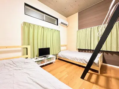 a bedroom with two bunk beds and a tv at HillTop Sendagi 102 in Tokyo