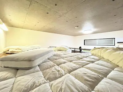a large white bed in a room with a tv at HillTop Sendagi 102 in Tokyo