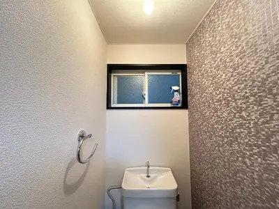 a bathroom with a toilet and a sink and a window at HillTop Sendagi 102 in Tokyo