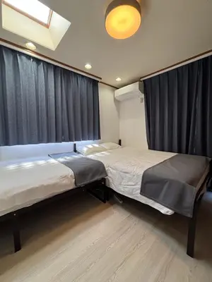 two beds in a room with black curtains at -Gyokuran- 6-minute walk from Shin-Okubo Station in Tokyo