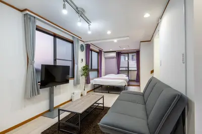 a living room with a couch and a bed at -Gyokuran- 6-minute walk from Shin-Okubo Station in Tokyo