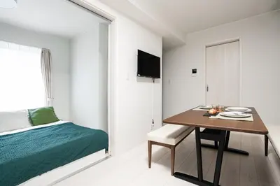 a bedroom with a dining room table and a bed at Sora Stay Shinjuku in Tokyo