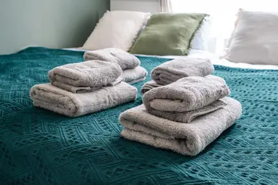 a pile of towels sitting on top of a bed at Sora Stay Shinjuku in Tokyo