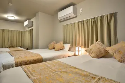a hotel room with three beds and a tv at Edo Art Hotel in Tokyo