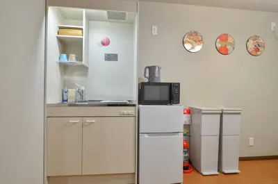 a kitchen with two refrigerators and a microwave at Edo Art Hotel in Tokyo