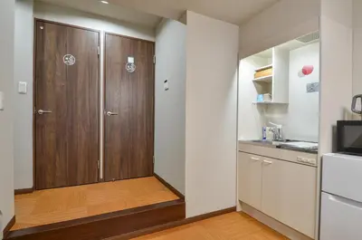 a kitchen with a wooden door in a room at Edo Art Hotel in Tokyo