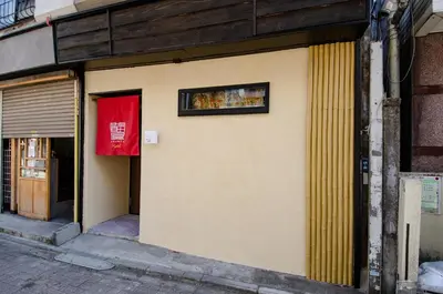 a building with a red sign on the side of it at Edo Art Hotel in Tokyo