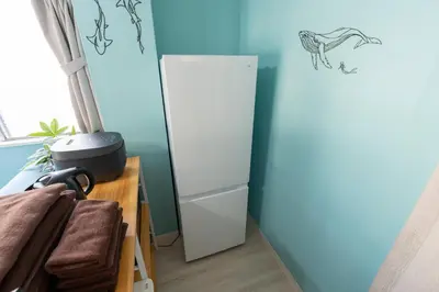 a refrigerator in a room with a blue wall at Tsumugi Yado \u897f\u845b\u897f in Tokyo