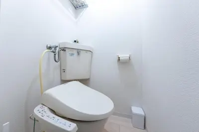 a bathroom with a white toilet with a remote control at Tsumugi Yado \u897f\u845b\u897f in Tokyo