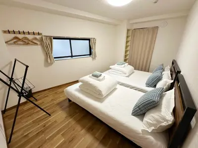 two twin beds in a room with a window at The Travelers Court Bunkyo II in Tokyo
