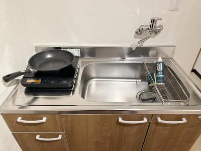 a kitchen sink with a frying pan on it at The Travelers Court Bunkyo II in Tokyo
