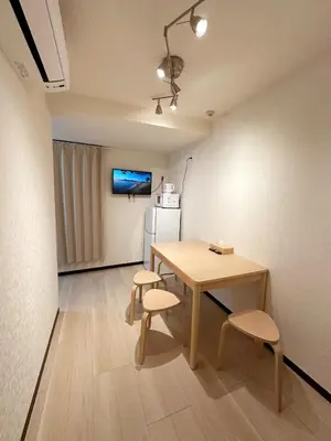 a room with a table and two chairs and a refrigerator at The Travelers Court Bunkyo II in Tokyo