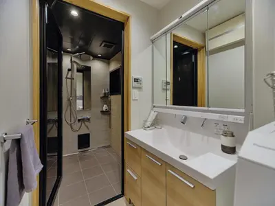 a bathroom with a sink and a shower and a mirror at NEW Hotel Komugi Skytree - modern Japanese-style guesthouse near Asakusa & Skytree 3mins, whole house rental perfect for large groups up to 14pax in Tokyo