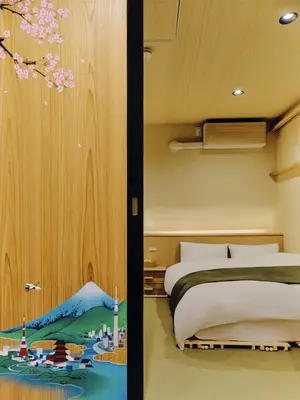a bedroom with a bed and a painting on the wall at NEW Hotel Komugi Skytree - modern Japanese-style guesthouse near Asakusa & Skytree 3mins, whole house rental perfect for large groups up to 14pax in Tokyo