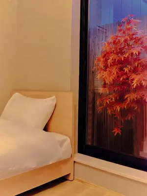 a bedroom with a bed and a window with a red plant at NEW Hotel Komugi Skytree - modern Japanese-style guesthouse near Asakusa & Skytree 3mins, whole house rental perfect for large groups up to 14pax in Tokyo