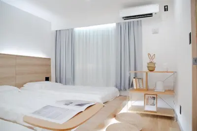 a white bedroom with a large bed and a window at ISSHUKU Noma \u5317\u65b0\u5bbfI -202 Triple Room in Tokyo