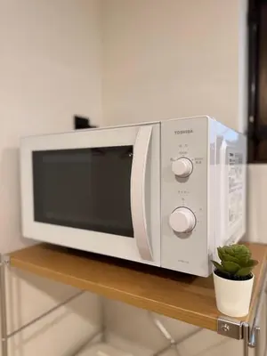 a microwave oven sitting on top of a wooden shelf at ISSHUKU Noma \u5317\u65b0\u5bbfI -202 Triple Room in Tokyo