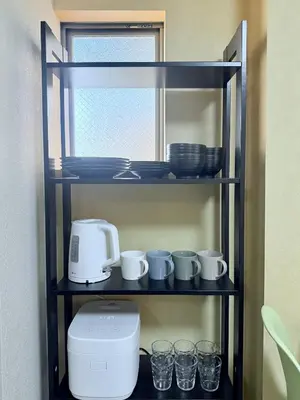 a shelf with cups and dishes and a coffee maker at Tokyo Stay Itabashi #202 in Tokyo