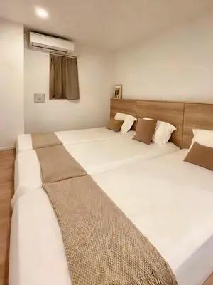 two beds in a room with twothirdsebin at ISSHUKU Noma \u5317\u65b0\u5bbfI -203 Triple Room in Tokyo