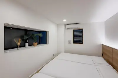 a white room with a bed and a window at ISSHUKU Noma \u5317\u65b0\u5bbfI -203 Triple Room in Tokyo