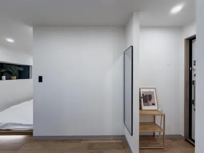 a bedroom with a white wall and a mirror at ISSHUKU Noma \u5317\u65b0\u5bbfI -203 Triple Room in Tokyo