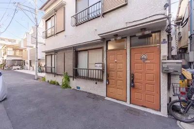 a building with brown doors on the side of a street at Sanyouso in Tokyo