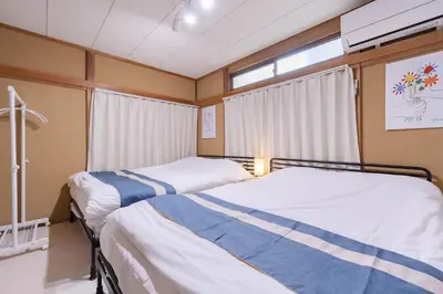 two beds in a room with a window at Sanyouso in Tokyo