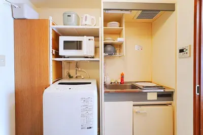 a small kitchen with a refrigerator and a microwave at 10 minutes to Shibuya by train, 2 beds, great access, Yoyogi Uehara in Tokyo