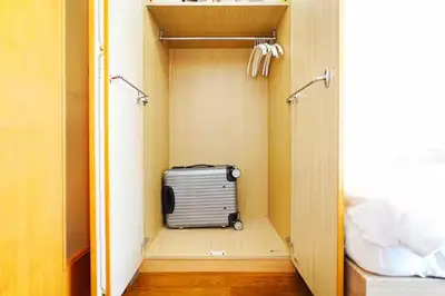 a suitcase is sitting in a walkway in a room at 10 minutes to Shibuya by train, 2 beds, great access, Yoyogi Uehara in Tokyo