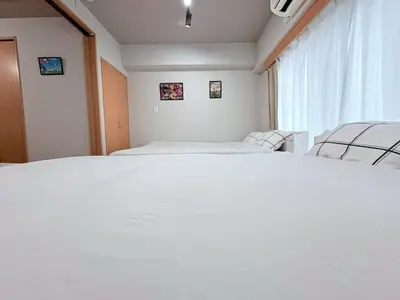 a bedroom with two beds and a window at GARDEN HOUSE Shinjuku-Sanchome 2 in Tokyo