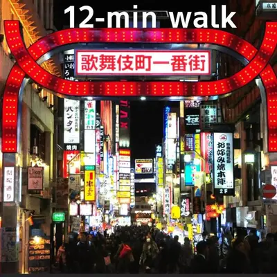 a busy city street at night with neon signs at GARDEN HOUSE Shinjuku-Sanchome 2 in Tokyo