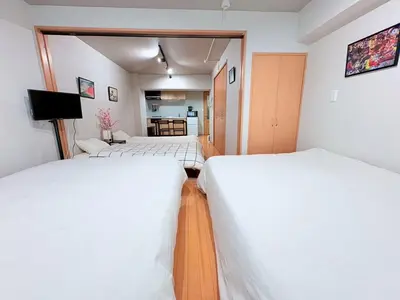 a room with three beds and a kitchen at GARDEN HOUSE Shinjuku-Sanchome 2 in Tokyo