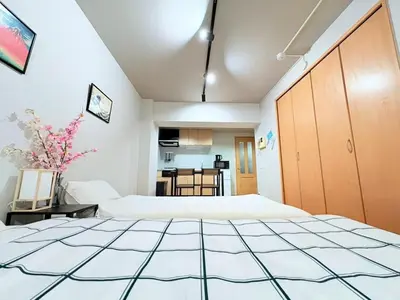 a room with two beds and a kitchen at GARDEN HOUSE Shinjuku-Sanchome 2 in Tokyo