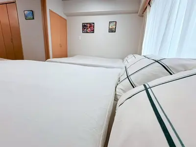 two beds in a small room with a window at GARDEN HOUSE Shinjuku-Sanchome 2 in Tokyo