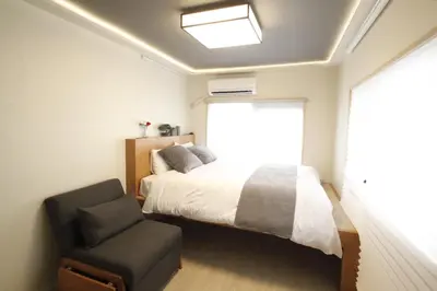 a bedroom with a bed and a chair and a window at Shibuya Shinjuku area Designer apartment in Tokyo