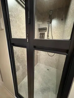 a glass door with a view of a shower at Shibuya Shinjuku area Designer apartment in Tokyo