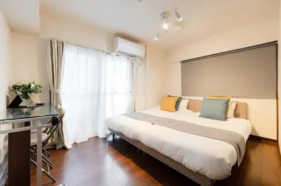 a bedroom with a bed and a desk and a window at \u30db\u30c6\u30eb\u5bcc\u58eb\u898b\u30de\u30f3\u30b7\u30e7\u30f3301 in Tokyo