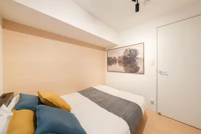 a bedroom with a bed and a painting on the wall at \u30db\u30c6\u30eb\u5bcc\u58eb\u898b\u30de\u30f3\u30b7\u30e7\u30f3301 in Tokyo