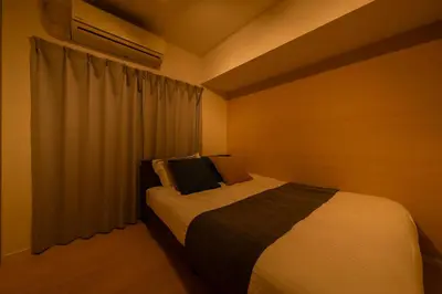 a bedroom with a bed and a window with curtains at \u30db\u30c6\u30eb\u5bcc\u58eb\u898b\u30de\u30f3\u30b7\u30e7\u30f3301 in Tokyo