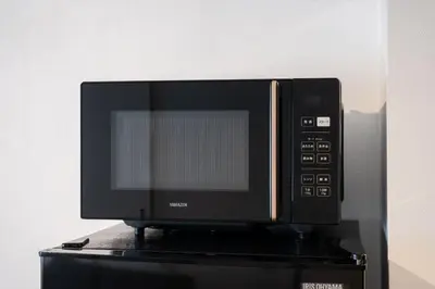 a microwave oven sitting on top of a table at \u30db\u30c6\u30eb\u5bcc\u58eb\u898b\u30de\u30f3\u30b7\u30e7\u30f3301 in Tokyo