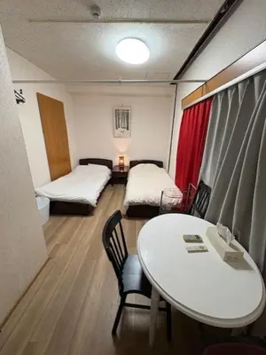 a room with two beds and a table and chairs at Azabu House in Tokyo