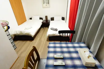 a small room with two beds and a table at Azabu House in Tokyo