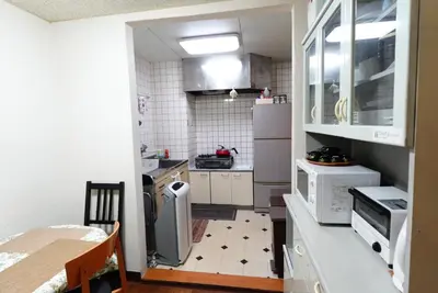 a small kitchen with white appliances and a table at Azabu House in Tokyo
